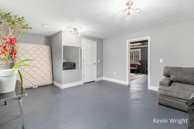 living room with baseboards and concrete flooring