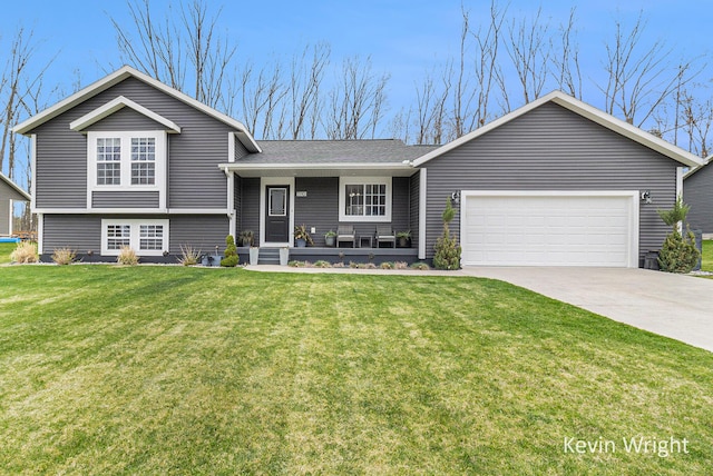tri-level home with an attached garage, driveway, a front yard, and covered porch