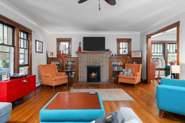 1754 Jackson Ave, Ann Arbor, MI 48103 - living area featuring crown molding, ceiling fan, a brick fireplace, and hardwood / wood-style floors