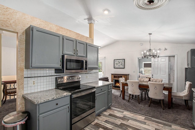 17653 Hiawatha Dr, Spring Lake, MI 49456 - kitchen featuring appliances with stainless steel finishes, gray cabinets, lofted ceiling, wood finished floors, and decorative backsplash