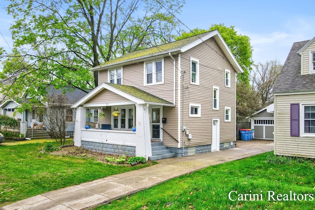 view of front of home featuring a porch, a garage, a front lawn, and an outbuilding