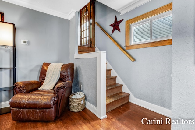 interior space featuring crown molding, baseboards, wood finished floors, and stairway