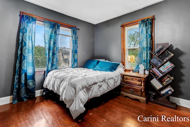 bedroom with baseboards and wood finished floors