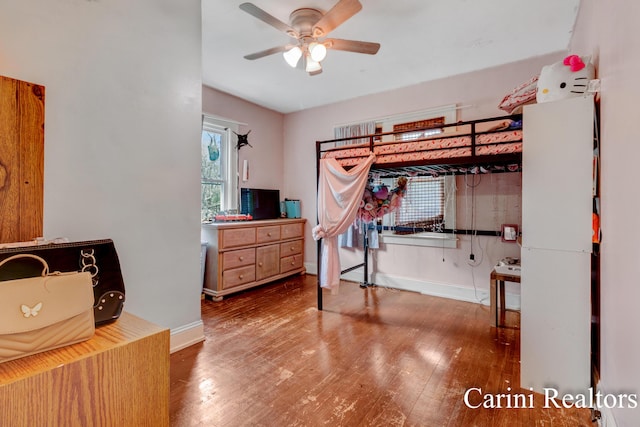 bedroom featuring baseboards, ceiling fan, and wood finished floors