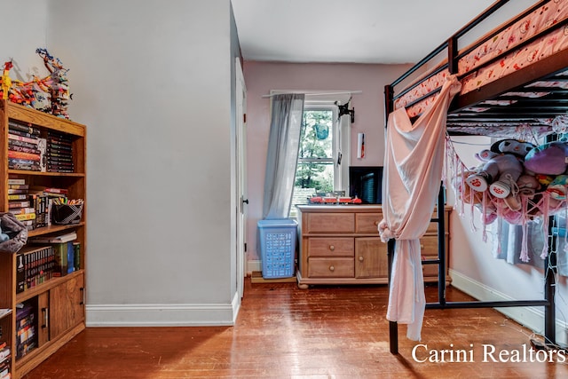 bedroom with baseboards and wood finished floors