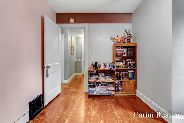 hall featuring baseboards and wood finished floors