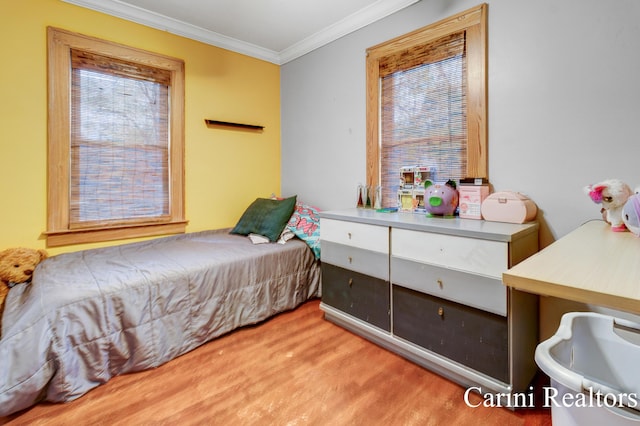 bedroom with ornamental molding, wood finished floors, and multiple windows