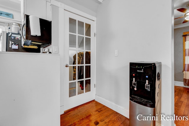 kitchen featuring a ceiling fan, baseboards, and wood finished floors