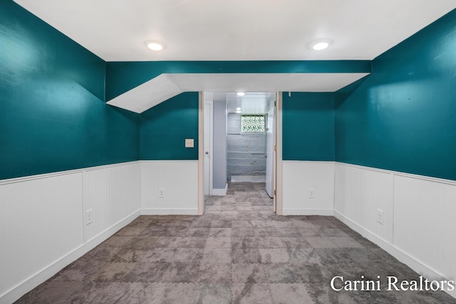 unfurnished room with a wainscoted wall and carpet