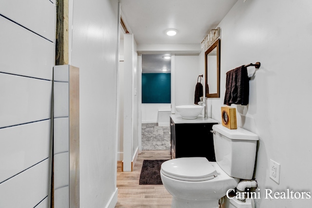 bathroom with vanity, baseboards, toilet, and wood finished floors
