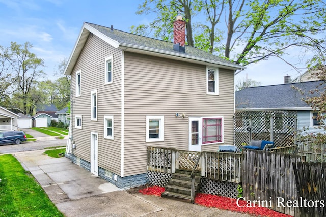 rear view of house with fence and a chimney