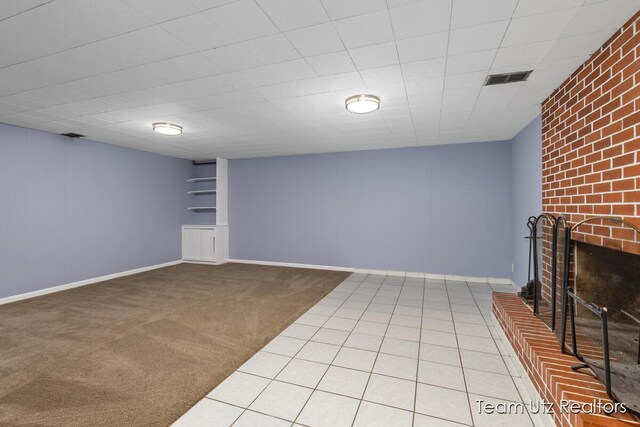 unfurnished living room with baseboards, light colored carpet, visible vents, and a fireplace