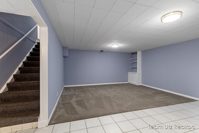finished basement with baseboards, carpet, and stairway