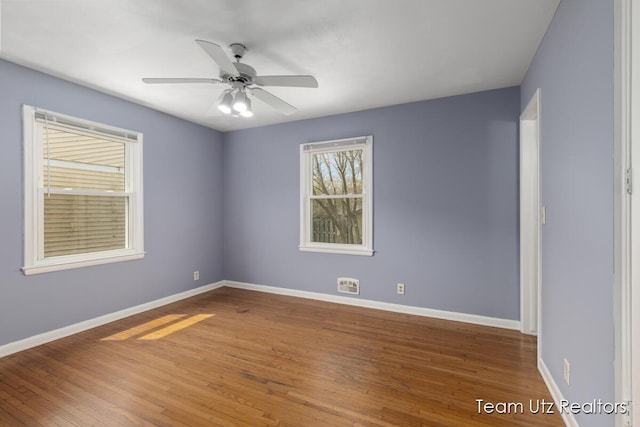 spare room featuring baseboards and wood finished floors