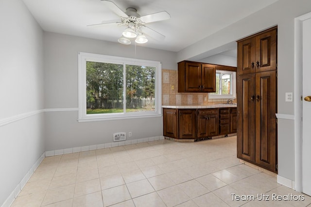 kitchen featuring a sink, decorative backsplash, plenty of natural light, and a ceiling fan