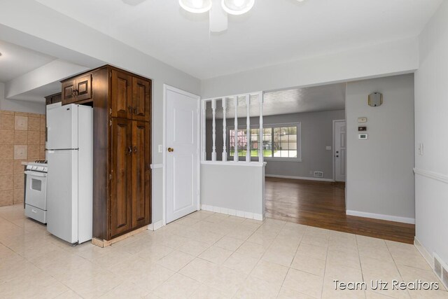 kitchen with baseboards, ceiling fan, white appliances, and light tile patterned flooring
