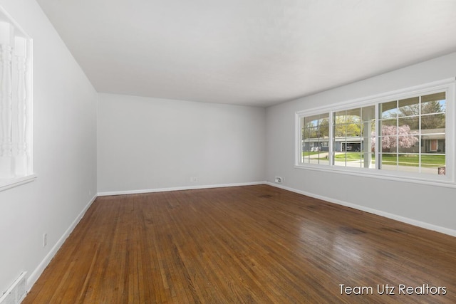empty room with visible vents, baseboards, and wood finished floors