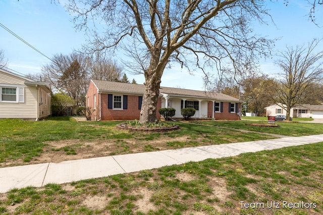 ranch-style home with brick siding, a front yard, and a porch