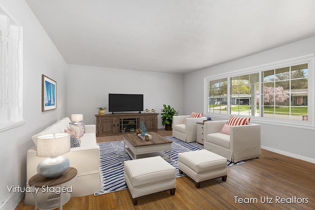 living area with baseboards and wood finished floors