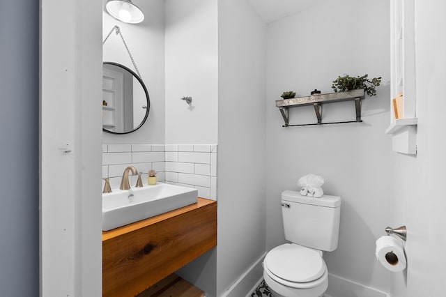 1021 Roseland Ave, Kalamazoo, MI 49001 - half bathroom featuring vanity and decorative backsplash