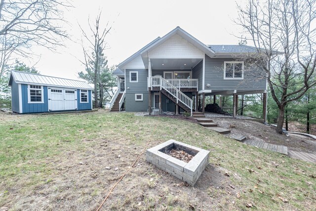 14 N Lighthouse Dr, Mears, MI 49436 - back of property featuring stairs, an outdoor structure, an outdoor fire pit, a carport, and a yard