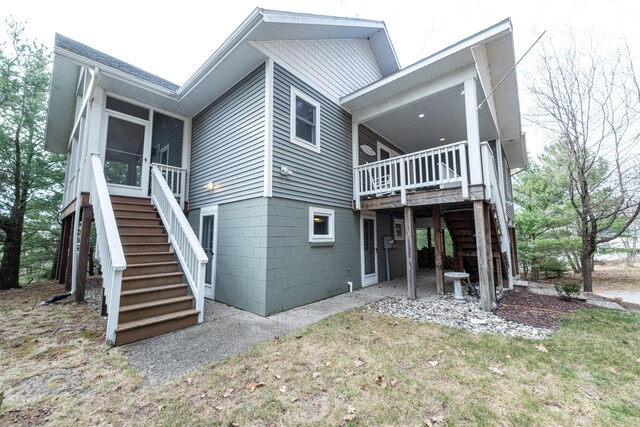 14 N Lighthouse Dr, Mears, MI 49436 - rear view of property with a sunroom, stairway, and a deck