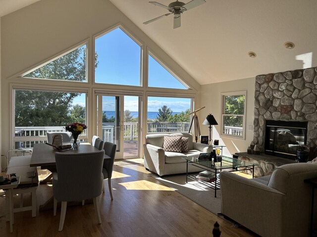14 N Lighthouse Dr, Mears, MI 49436 - living area featuring a stone fireplace, ceiling fan, wood finished floors, and high vaulted ceiling