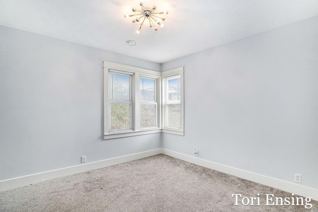 unfurnished room with baseboards and carpet