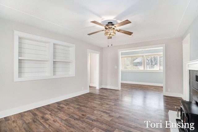 unfurnished living room featuring built in features, baseboards, a ceiling fan, and wood finished floors