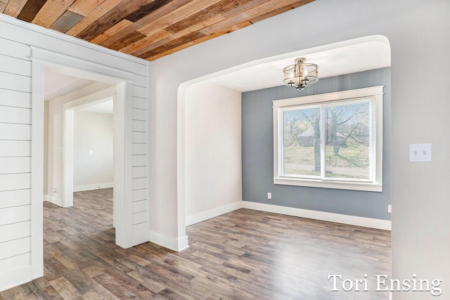 spare room featuring wood ceiling, baseboards, a chandelier, and wood finished floors