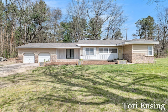 ranch-style house with an attached garage, a front yard, driveway, and brick siding