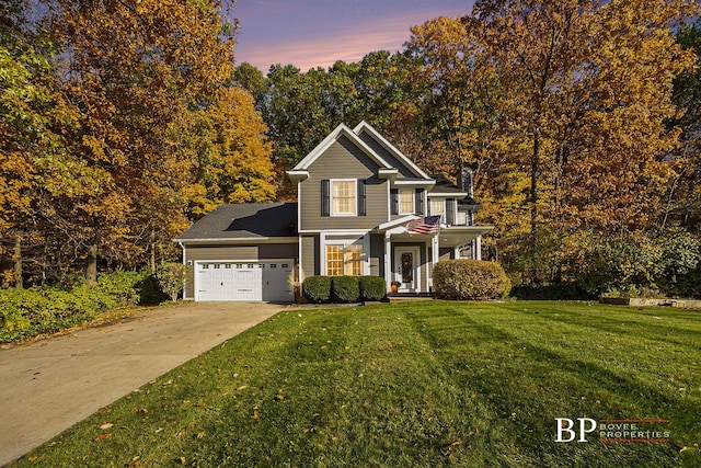 traditional-style home with a garage, a front lawn, and driveway