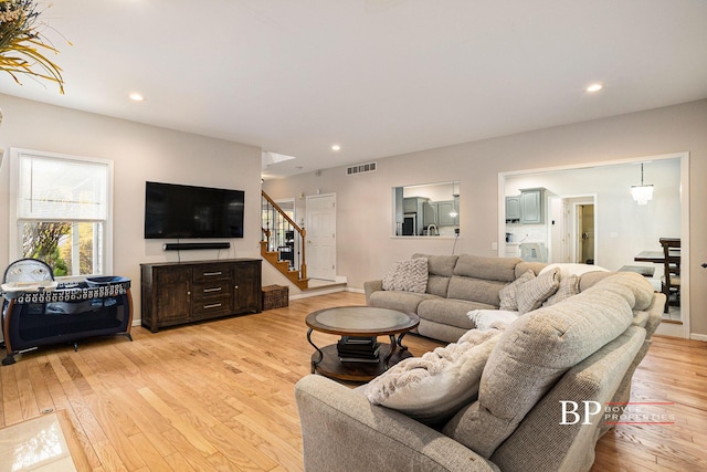 living area with visible vents, recessed lighting, stairs, and light wood-style floors
