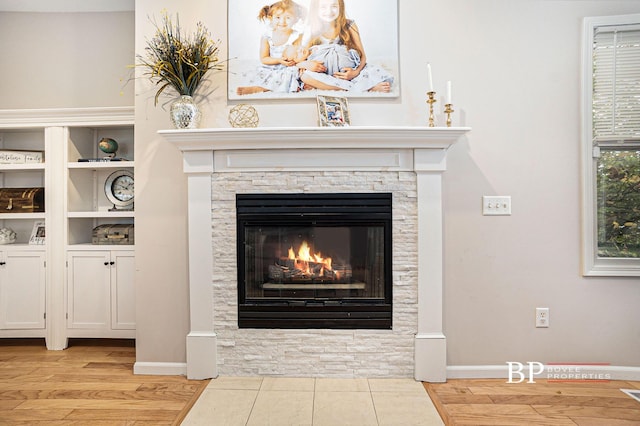 room details featuring baseboards, wood finished floors, and a fireplace