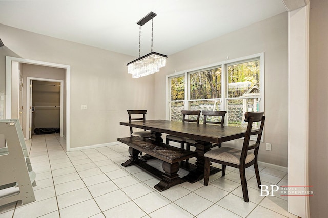 dining room featuring baseboards, a chandelier, and light tile patterned flooring