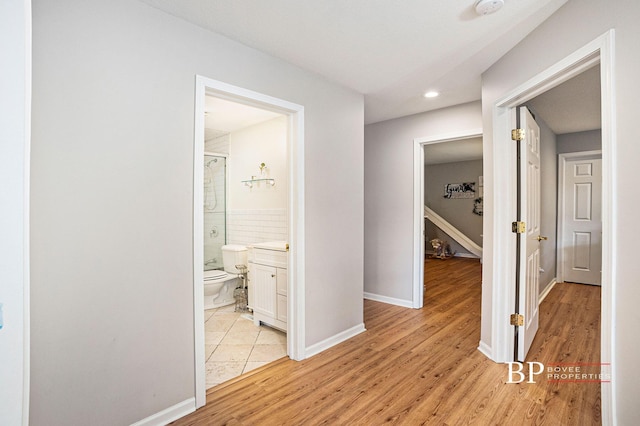 hall with recessed lighting, light wood finished floors, and baseboards