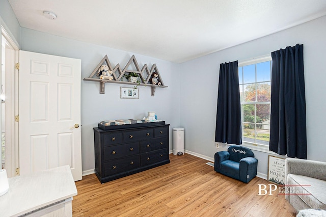 sitting room with light wood-style floors, baseboards, and plenty of natural light