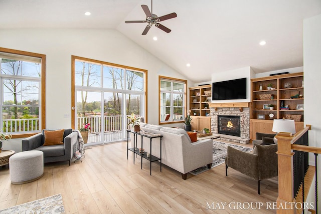 13460 Cottage View Ct, Gowen, MI 49326 - living area featuring ceiling fan, a stone fireplace, high vaulted ceiling, light wood-style floors, and recessed lighting