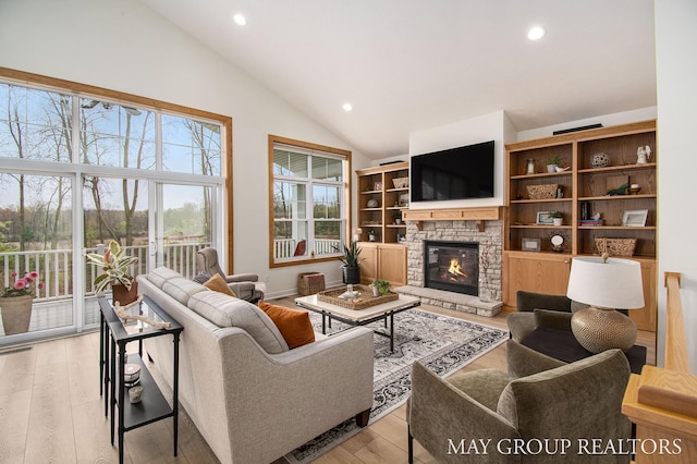13460 Cottage View Ct, Gowen, MI 49326 - living area with vaulted ceiling, a stone fireplace, recessed lighting, and light wood-type flooring