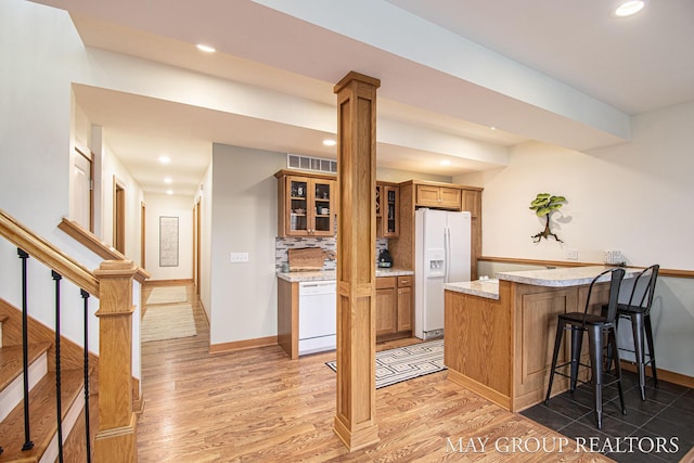13460 Cottage View Ct, Gowen, MI 49326 - kitchen featuring white appliances, a peninsula, recessed lighting, brown cabinets, and baseboards