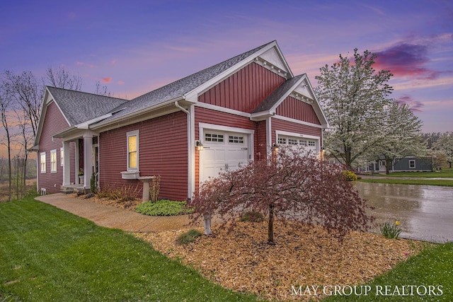 13460 Cottage View Ct, Gowen, MI 49326 - property exterior at dusk with board and batten siding, a shingled roof, a garage, a lawn, and a water view