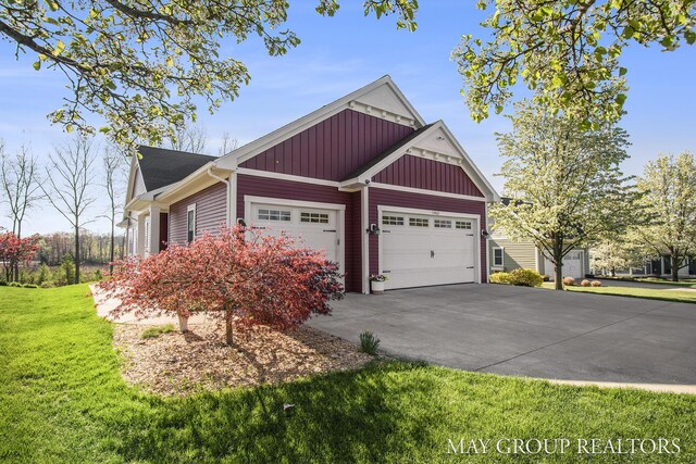 13460 Cottage View Ct, Gowen, MI 49326 - view of side of home with board and batten siding, concrete driveway, a garage, and a lawn