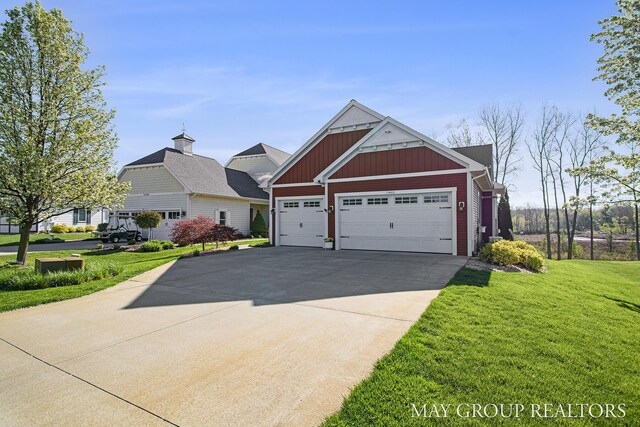 13460 Cottage View Ct, Gowen, MI 49326 - view of front of home with board and batten siding, a front yard, concrete driveway, and a garage