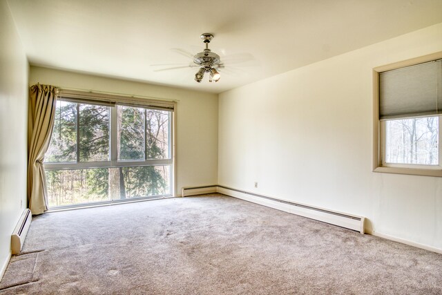 20425 Thornapple Ln, Big Rapids, MI 49307 - spare room with carpet flooring, ceiling fan, a baseboard heating unit, and a wealth of natural light