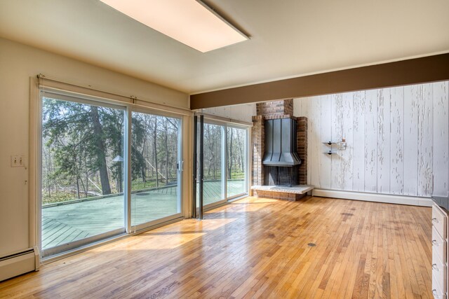 20425 Thornapple Ln, Big Rapids, MI 49307 - unfurnished living room featuring wood-type flooring, wooden walls, baseboards, and baseboard heating