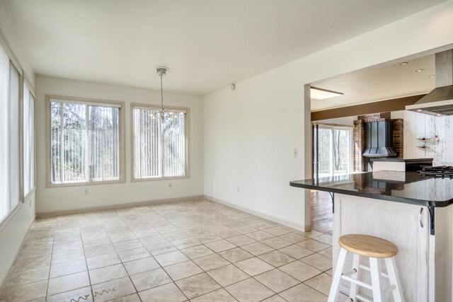 20425 Thornapple Ln, Big Rapids, MI 49307 - kitchen featuring hanging light fixtures, an inviting chandelier, a breakfast bar area, baseboards, and light tile patterned floors