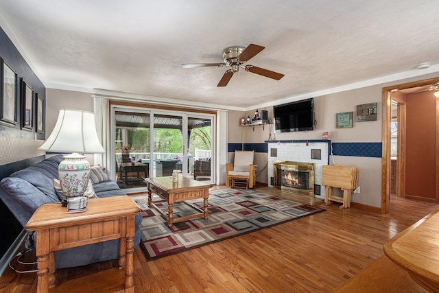 409 Louise Ave, Dowagiac, MI 49047 - living room with baseboards, a ceiling fan, wood finished floors, and a brick fireplace
