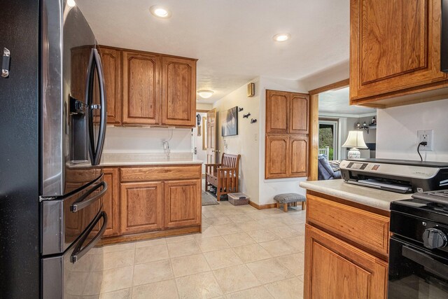 409 Louise Ave, Dowagiac, MI 49047 - kitchen with brown cabinetry, light countertops, light tile patterned floors, stainless steel fridge, and recessed lighting
