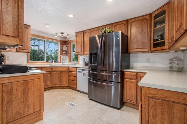 409 Louise Ave, Dowagiac, MI 49047 - kitchen with a sink, brown cabinetry, stainless steel refrigerator with ice dispenser, and dishwasher