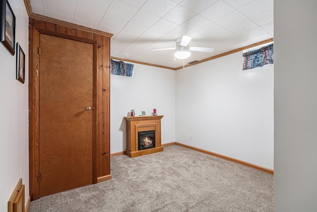 409 Louise Ave, Dowagiac, MI 49047 - living room featuring carpet flooring, ceiling fan, baseboards, a lit fireplace, and ornamental molding